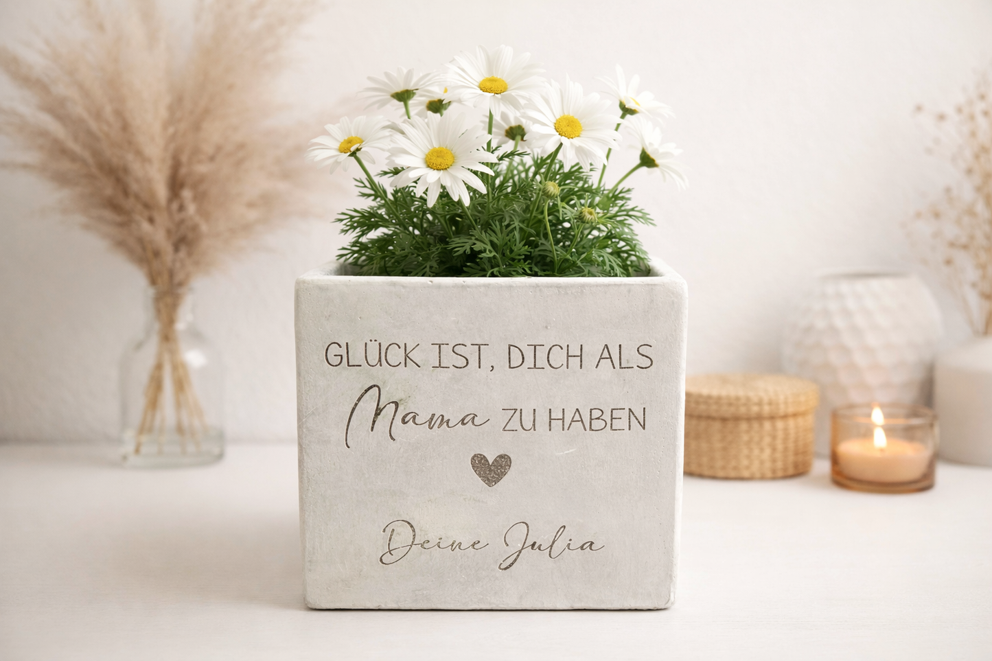 Personalisierter Blumentopf mit Gravur im minimalistischen Wohnstil. Zwei weiße Margeriten stehen in einem länglichen Betonoptik Blumentopf mit Gravur und Herzmotiv. Geschenkidee für Muttertag, Geburtstag oder Weihnachten. Liebevolles Geschenk für Mama oder Oma als dekoratives Erinnerungsstück.