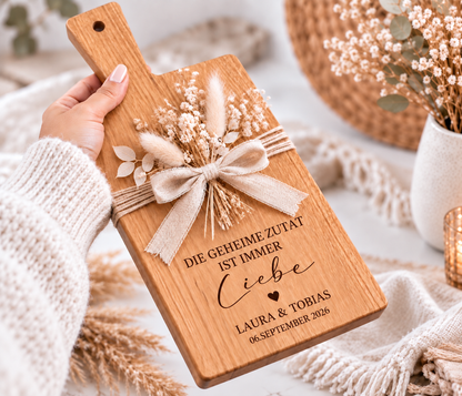 Individuell graviertes Holzbrett mit Griff als Geschenk zur Hochzeit, personalisiert mit Namen und Hochzeitsdatum für Braut und Bräutigam.
