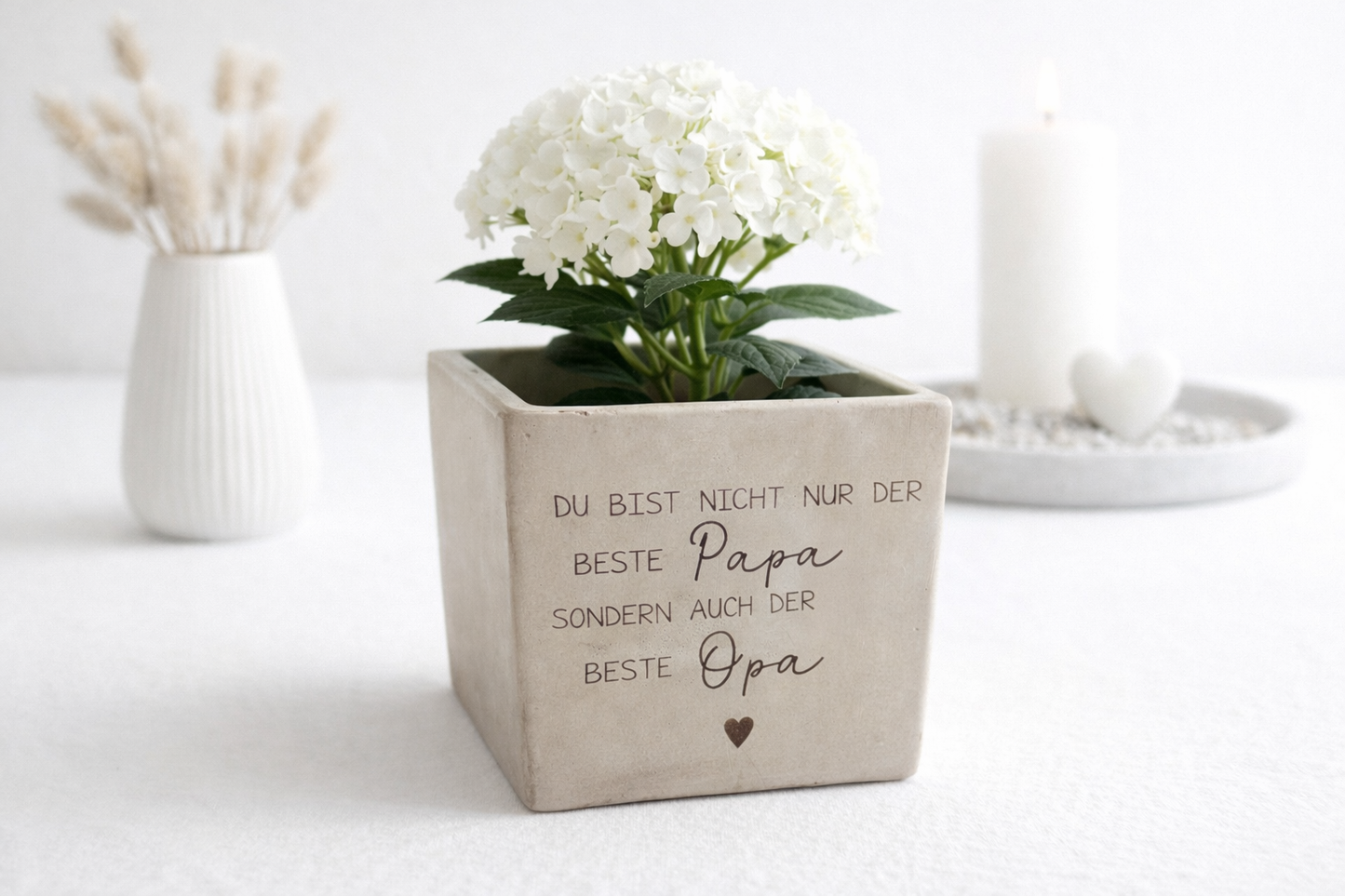 Personalisierter Blumentopf mit Gravur für Papa und Opa als Vatertagsgeschenk. Blumentopf personalisiert in Betonoptik mit weißer Hortensienpflanze. Dekoratives Wohnaccessoire mit emotionaler Botschaft für Papa und Opa. Geschenkidee zum Vatertag, Geburtstag oder Weihnachten. Stilvolle Dekoration für Wohnzimmer, Regal oder Tisch mit natürlicher Pflanze.