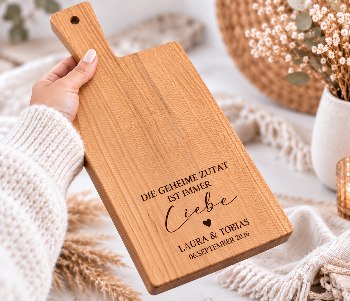 Graviertes Holzbrett als persönliches Hochzeitsgeschenk mit Namen des Brautpaares, Datum und Spruch „Die geheime Zutat ist immer Liebe“.
