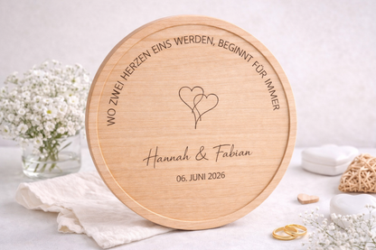 Graviertes Servierbrett zur Hochzeit mit zwei Herzen Motiv und individueller Namensgravur, dekoriert mit Eheringen und Blumen – personalisiertes Geschenk zur Trauung.