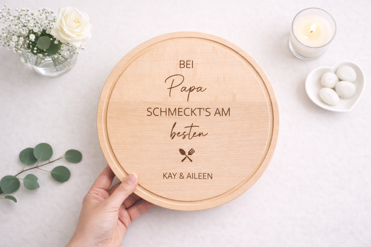 Holzbrett personalisiert für Papa mit Gravur " Bei Papa schmeckt's am besten" und individuellen Namen in handhaltend