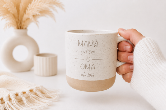 Personalisierte Steingut Tasse mit Gravur „Mama seit 1992 Oma ab 2026“ in einer Hand mit weißem Strickpullover vor modernem hellen Boho Hintergrund mit Pampasgras.
