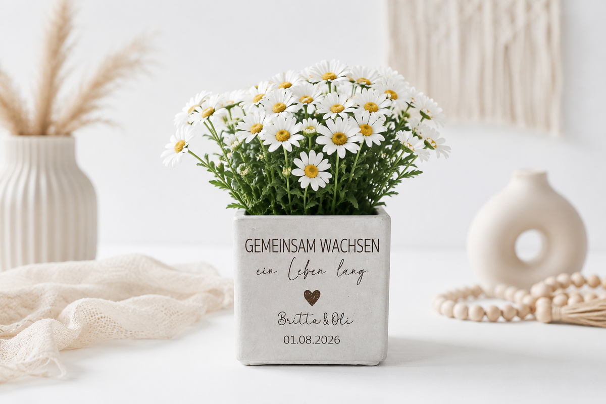 Personalisierter Blumentopf mit Spruch „Gemeinsam wachsen ein Leben lang“ in moderner Betonoptik mit weißen Margeriten, individuellen Namen und Datum – romantisches Hochzeitsgeschenk für Paare.